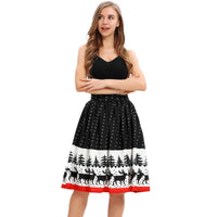 A woman with long hair is standing and smiling. She is wearing a black sleeveless top paired with a knee-length, high-waisted skirt featuring a festive pattern of trees and reindeer, complete with a red hem at the bottom. Her arms are relaxed by her sides as she enjoys her ladies' Christmas print wild party skirt.